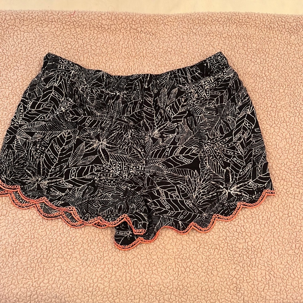 Black and white print shorts with pink accent on bottom. 100 percent rayon.